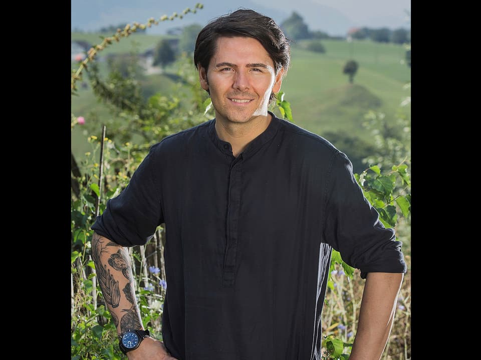 Porträt von Nenad Mlinarevic in einem schwarzen Hemd mit hochgekrempelten Ärmeln.
