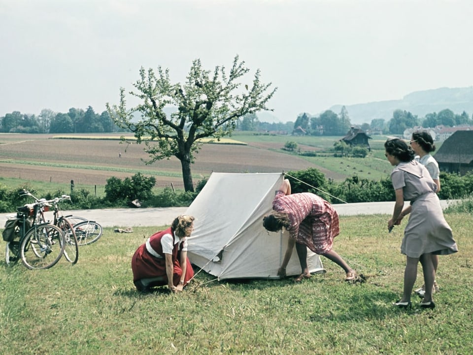 Junge Frauen geniessen im Mai 1944 einen Radausflug in ländlicher Gegend in der Schweiz und zelten auf einer Wiese. 