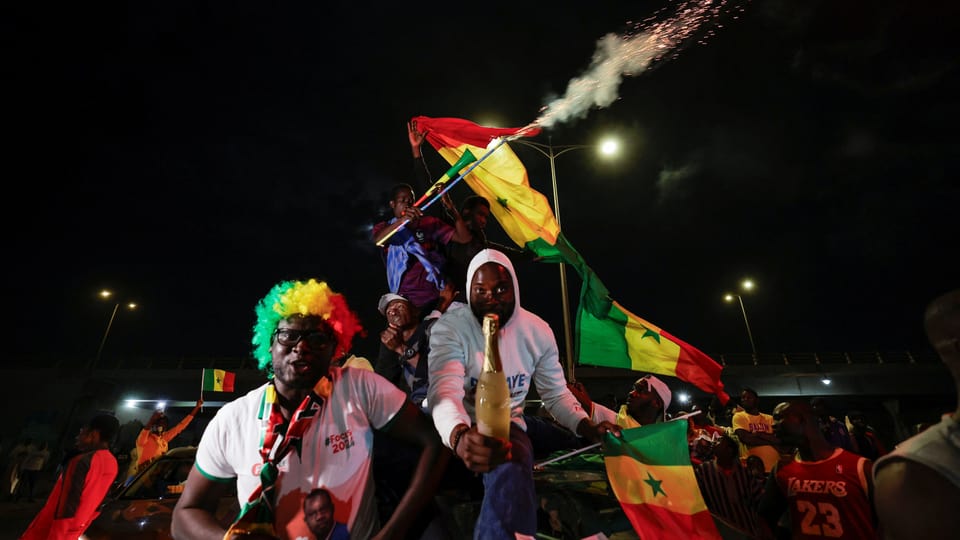 Feiernde Menschen mit Senegal-Flaggen