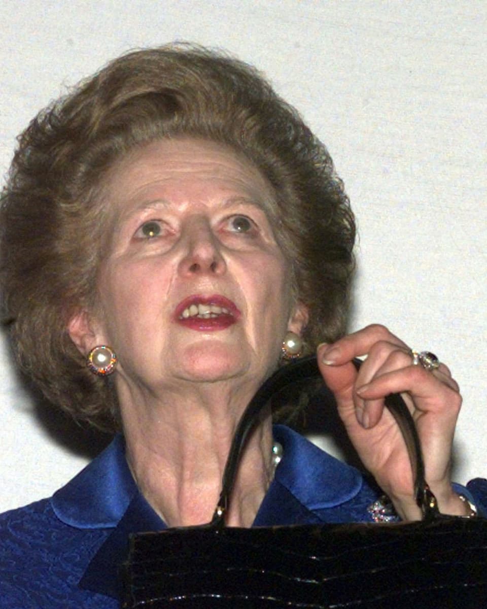 Margaret Thatcher hält ihre Handtasche und schaut gen Himmel.
