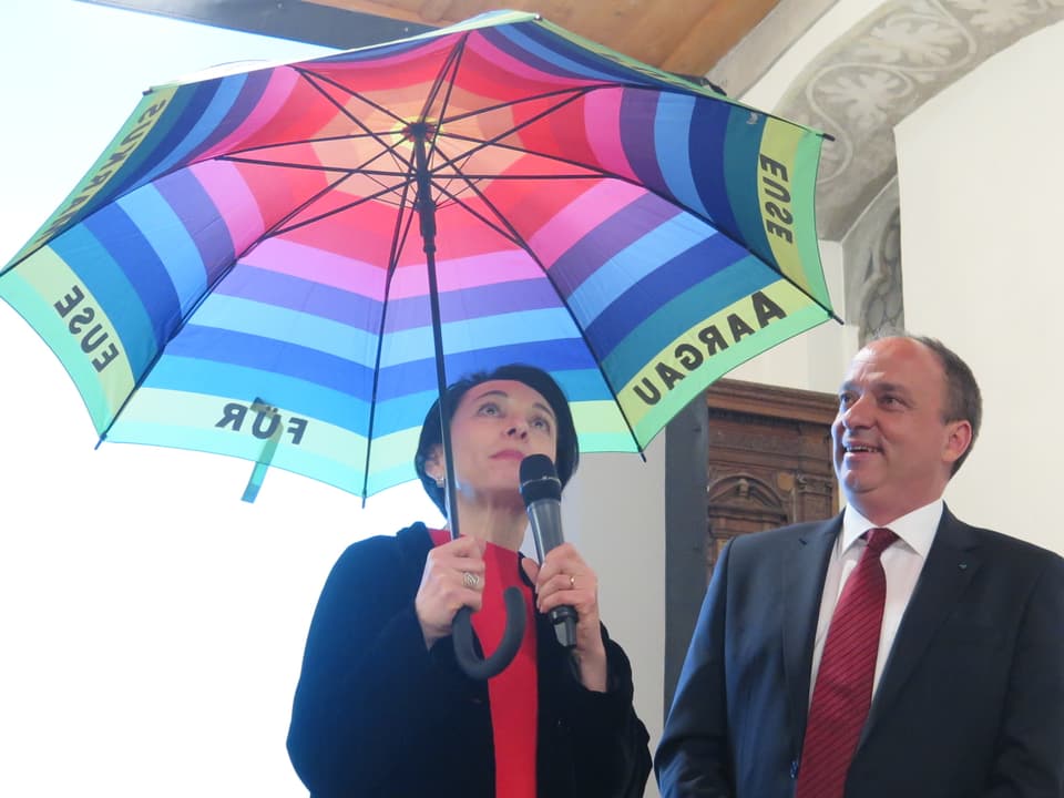 Markus Dieth erhält einen Schirm von Parteipräsidentin Marianne Binder.