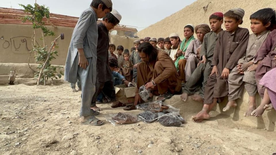 Afghanische Kinder probieren Schuhe aus.