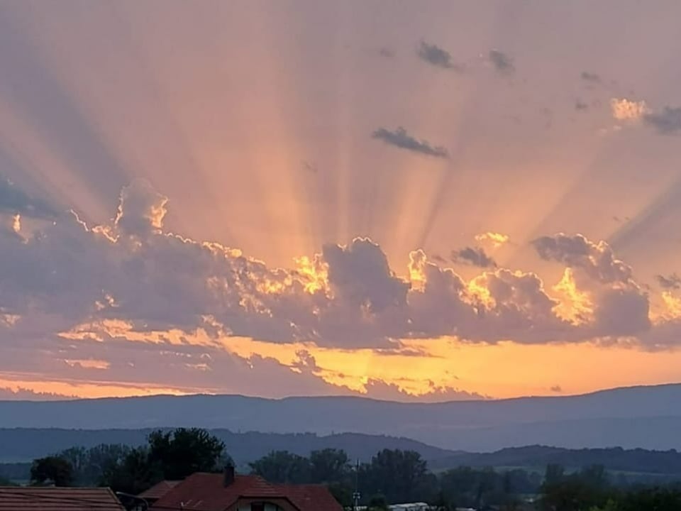 Strahlenbündel am Himmel der untergehenden Sonne.