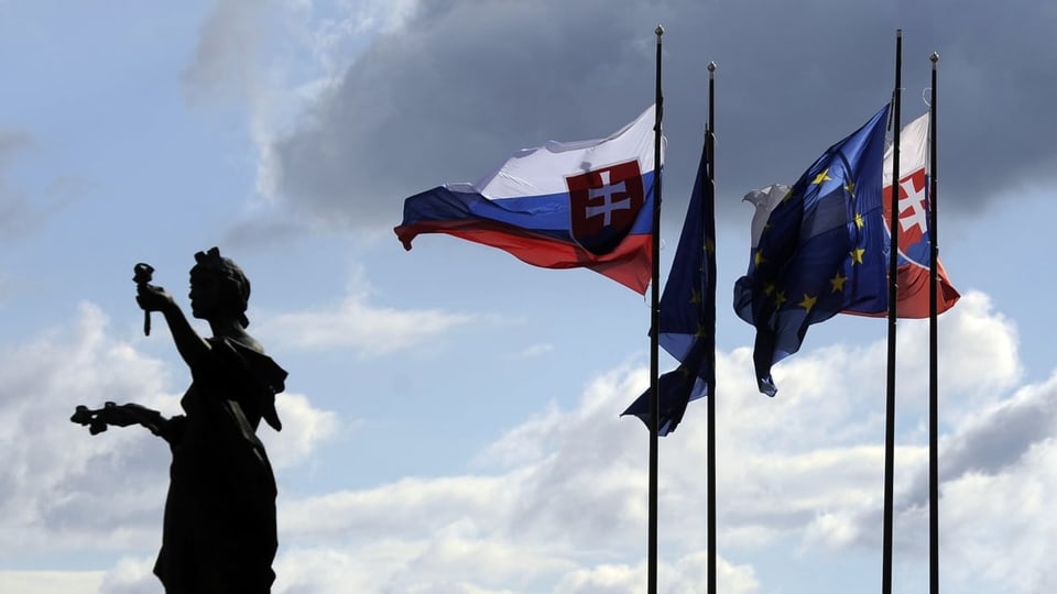 Dunkle Wolken ziehen über den EU und Slowakei-Flaggen auf.a