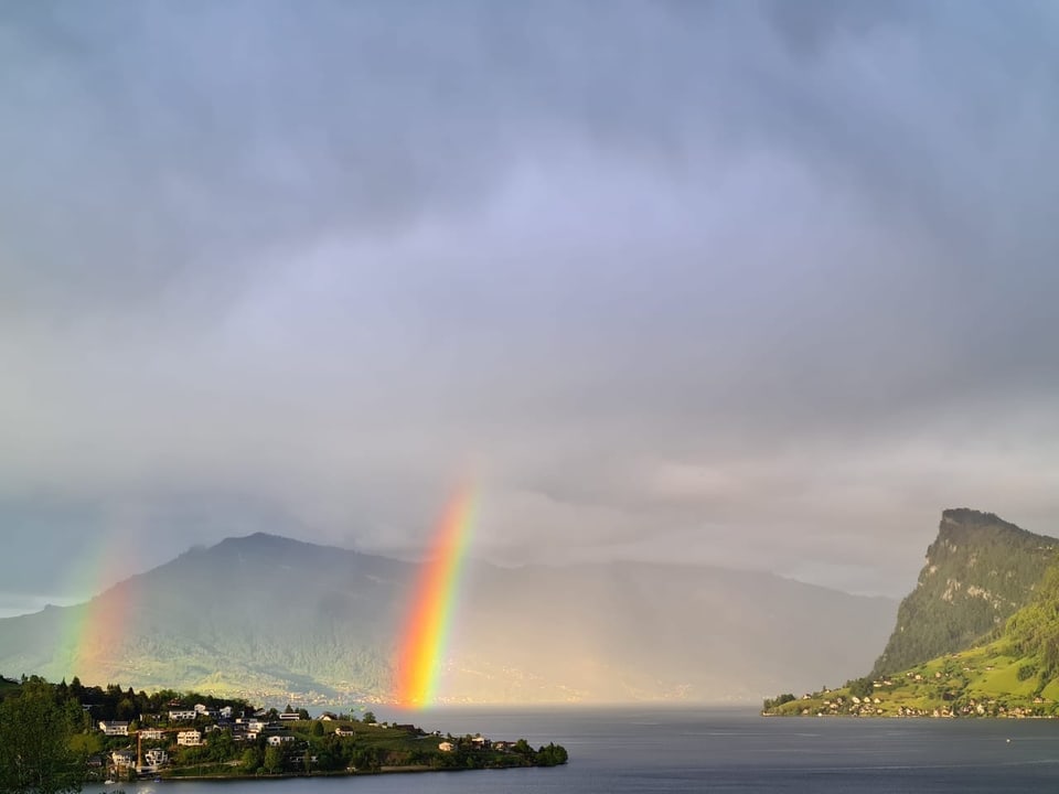 Doppelter Regenbogen über einem See.