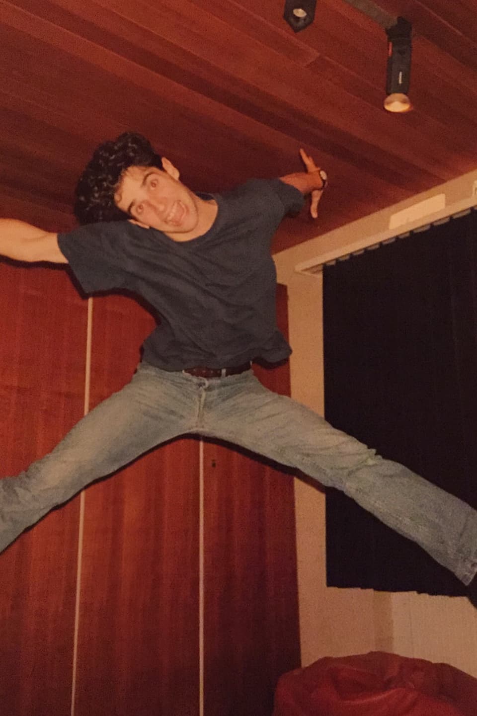 Philippe Gerber springt in einem holzgetäfertem Zimmer in die Luft.