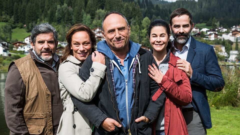 Die fünf Personen posieren lachend vor einem Bergdorf
