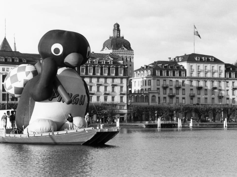 Die Trickfilmfigur "Pingu", ist in riesengrosser Ausführung auf einem Kahn in der Reuss in Luzern.