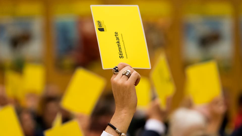 Symbolbild: Hände der BDP-Delegierten halten gelbe Stimmkarten in die Höhe.