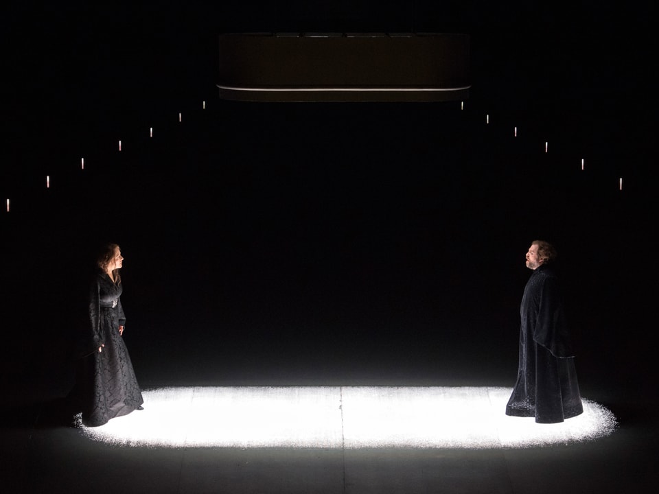 Ein Mann und eine Frau stehen sich im Lichtkegel auf einer Bühne gegenüber