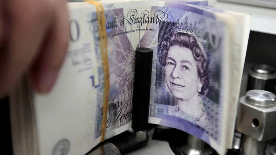Bündel Pfundnoten in einer Geldzählmaschine, gut sichtbar der Kopf der Queen auf der Note