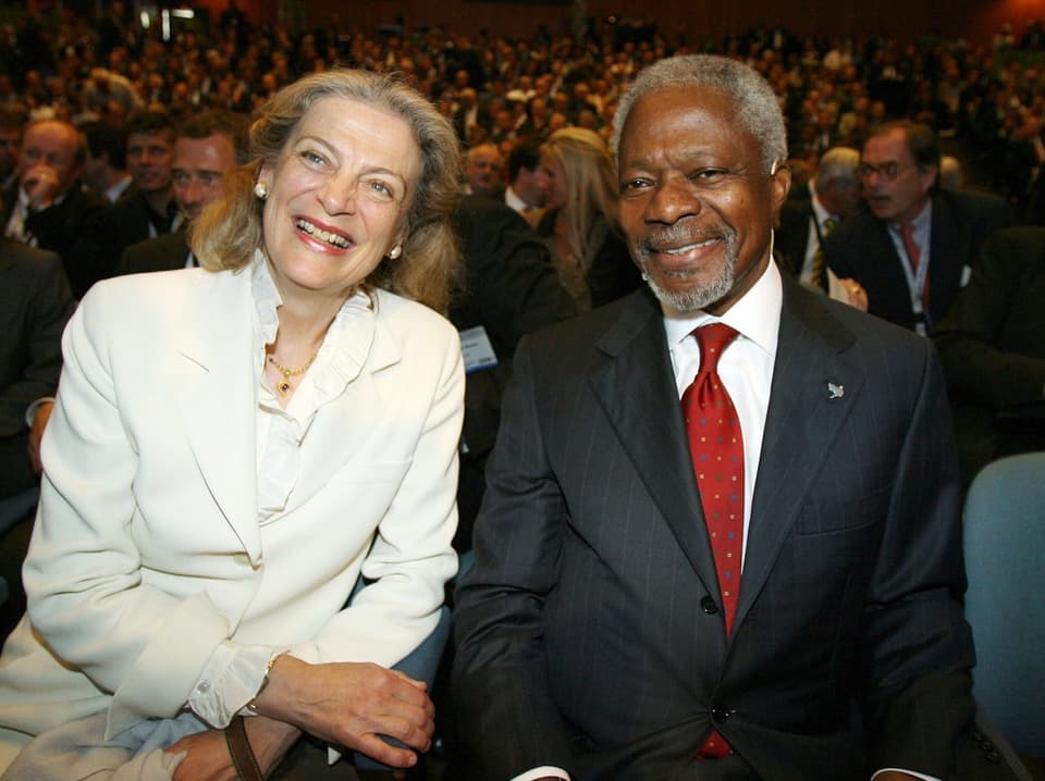 Kofi Annan sitzt mit seiner Frau im Publikum. Sie lächeln in die Kamera.