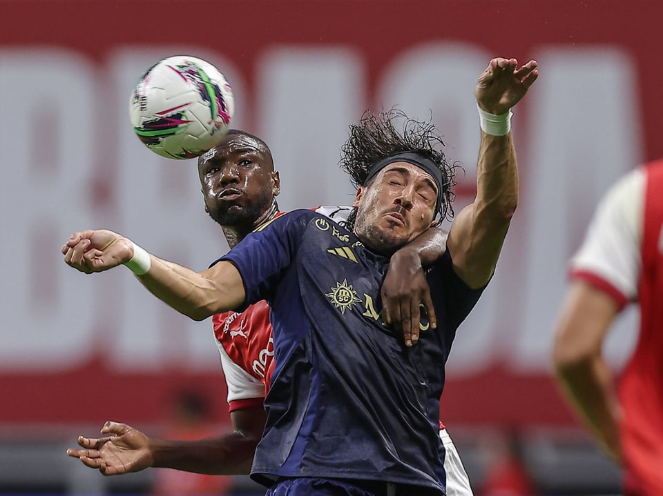 Two football players fighting for the ball in mid-air.