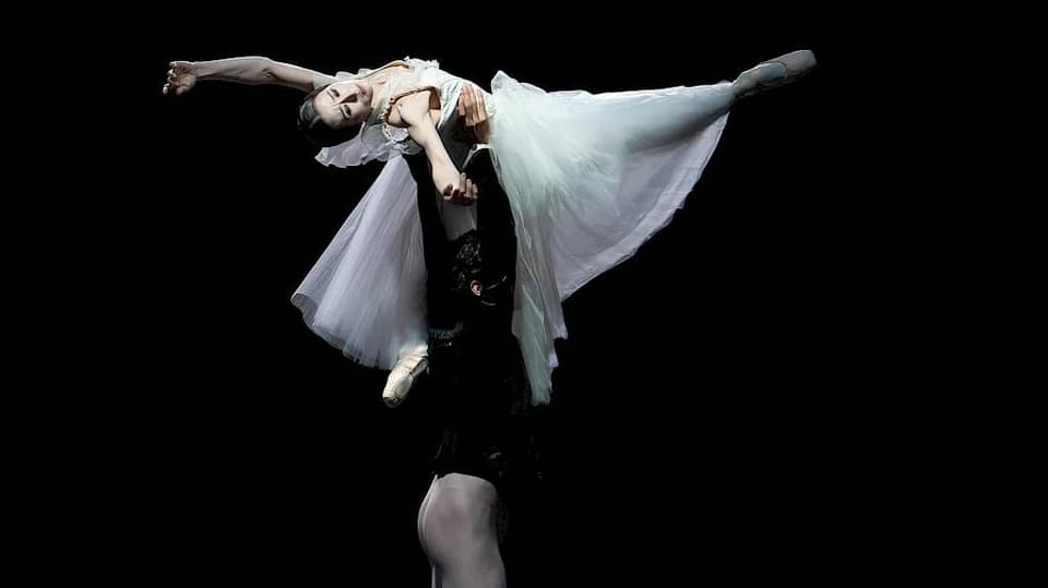 Ein Tänzer dreht eine Tänzerin in der Luft