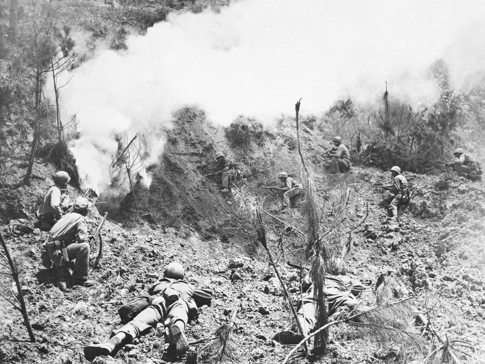 Soldaten beschiessen sich gegenseitig, im Hintergrund ist viel weisser Rauch zu sehen.