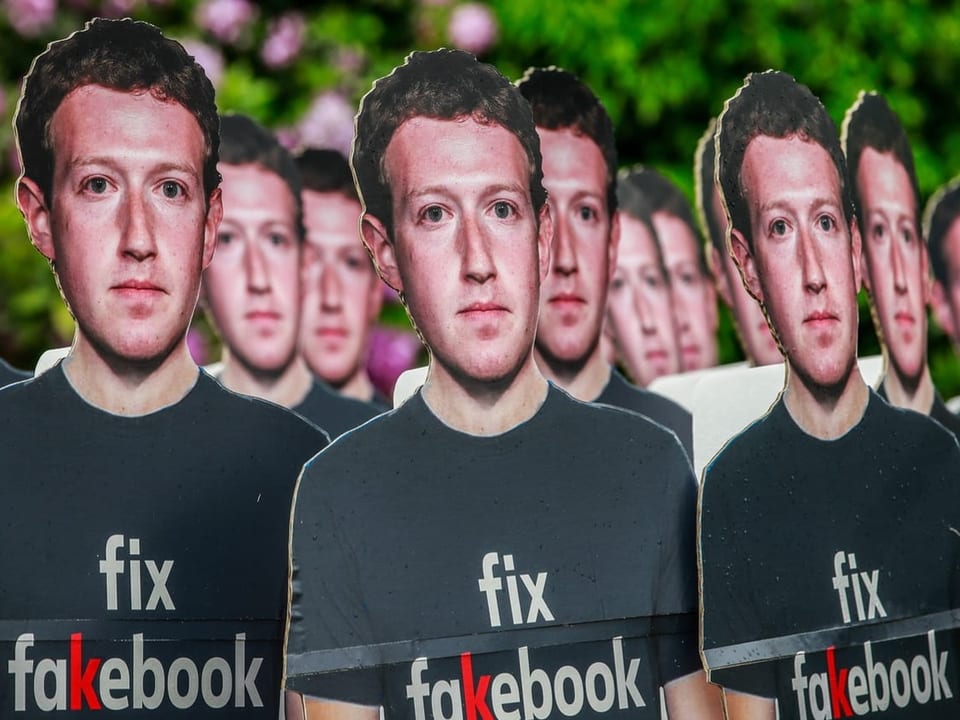 Papierfiguren mit dem Gesicht von Facebook-Gründer Mark Zuckerberg mit der Aufschrift «fix fakebook».