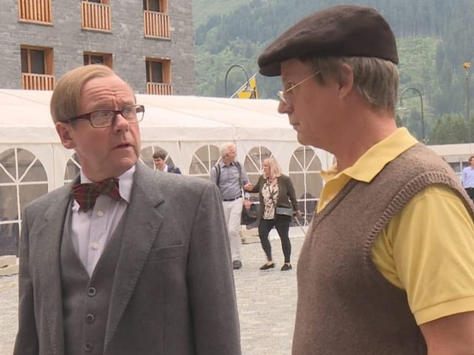 Zwei Männer stehen nebeneinander und schauen sich an.