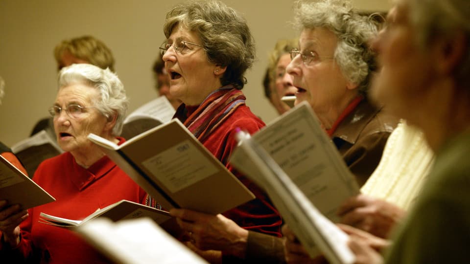 Ältere Frauen mit Gesangsbüchern.