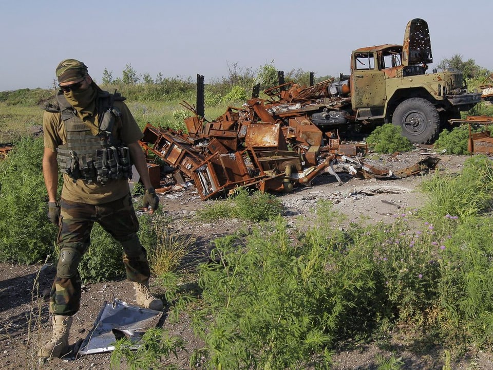 Ukrainischer Soldat vor zerstörtem Kriegsgerät.