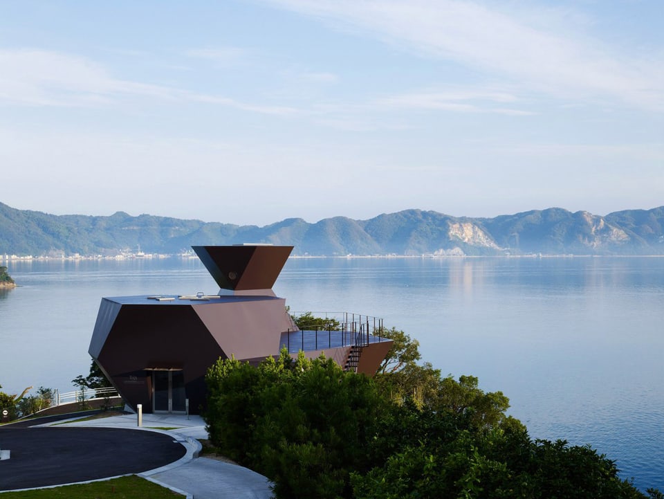 Das dunkelbraune, wabenartig geformte Toyo Ito Museum of Architecture steht erhaben an einem See.