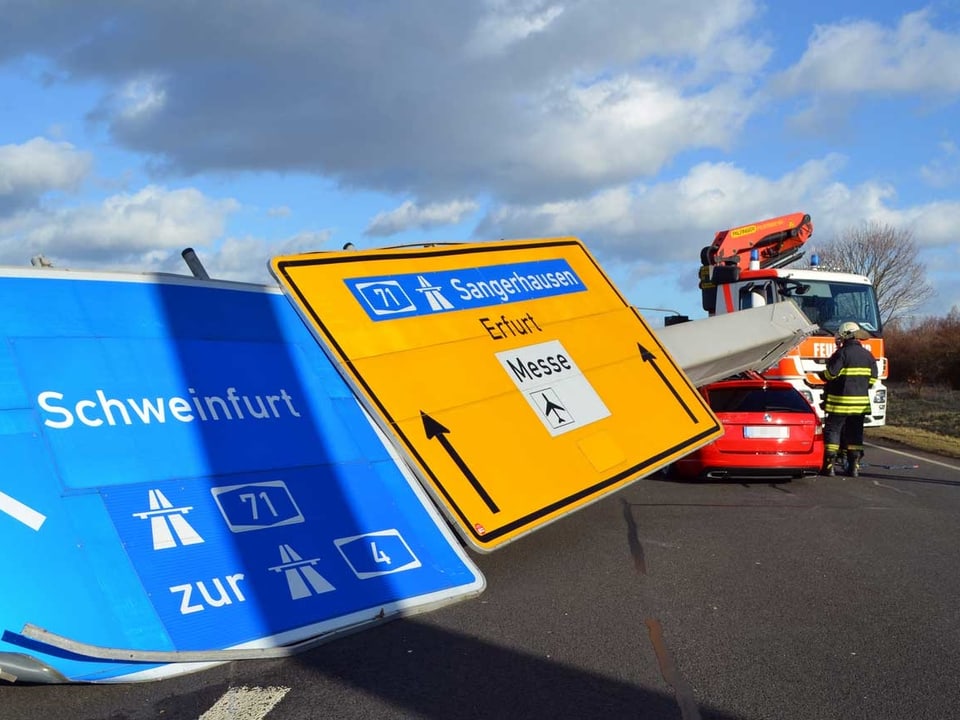 Autobahn-Wegweiser-Tafeln liegen auf einem Auto.