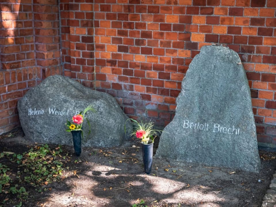 Zwei Grabsteine mit der Aufschrift «Helene Weigel-Brecht» und «Bertolt Brecht», davor Blumen