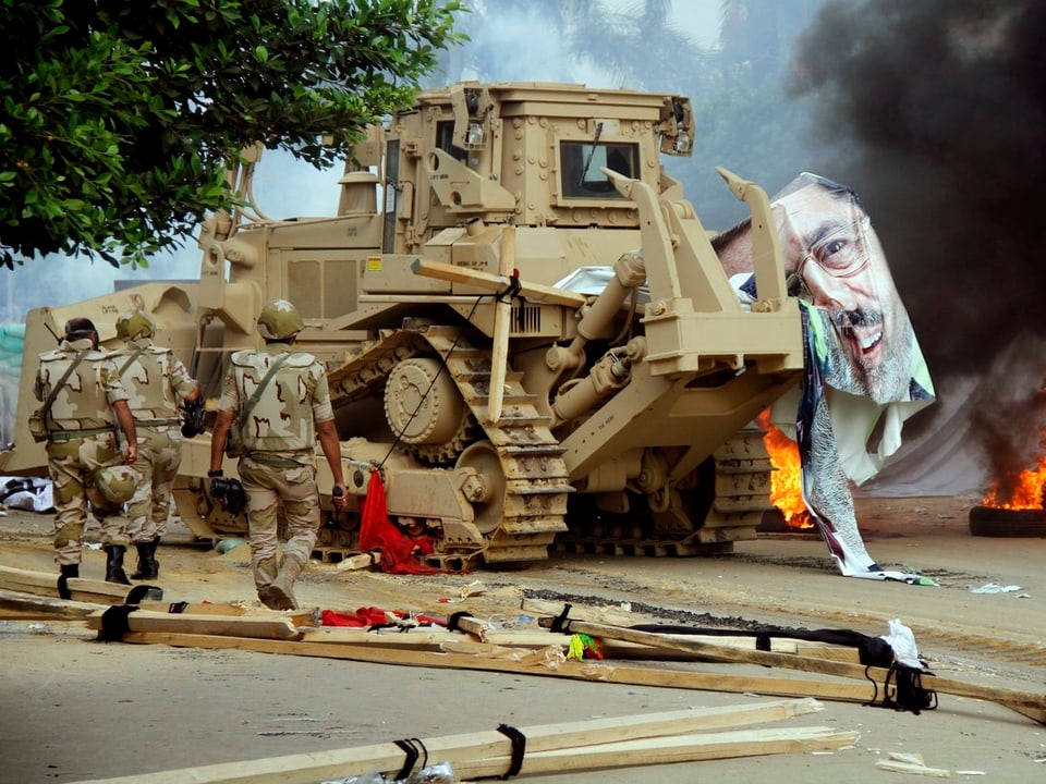 Bulldozer mit den Fetzen eines Mursi-Plakats