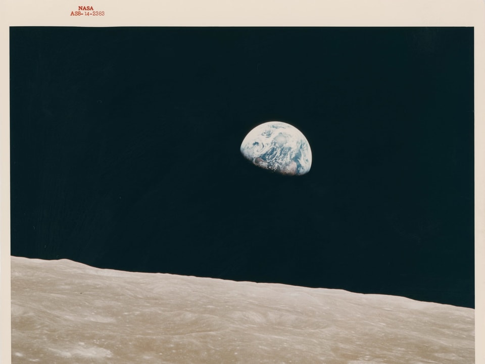 Blick vom Mond auf die Erde - die Erde als halbe Kugel sichtbar, umgeben von schwarz. 
