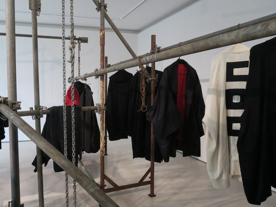 Kleidungsstücke aufgehängt an Eisenstangen.