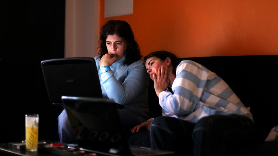 Zwei Frauen schauen gebannt auf den Bildschirm eine Laptops.
