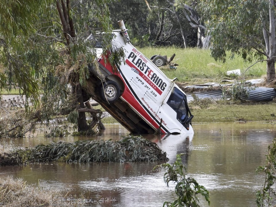 Ein Lieferwagen steht mit der vorderen Achse im beintiefen Wasser. Die Hinterachse schwebt in der Luft.