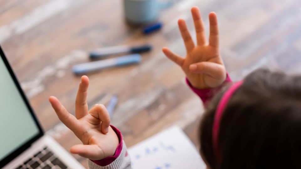 Ein Kind zählt mit seinen Fingern auf Sieben.