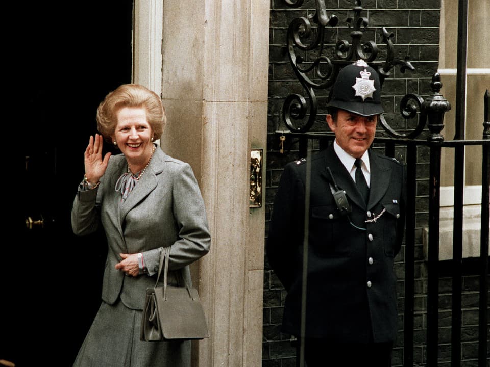 Margaret Thatcher winkt tadellos gekleidet in die Kamera.