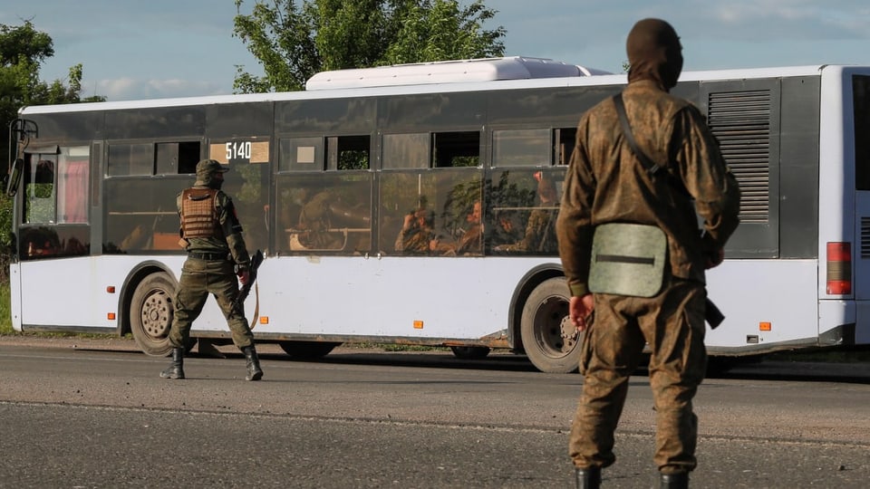 Soldaten vor einem Bus. 