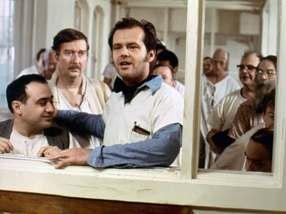 Jack Nicholson steht am Eingang zur Schwesternstation. Die anderen Patienten neben ihm.