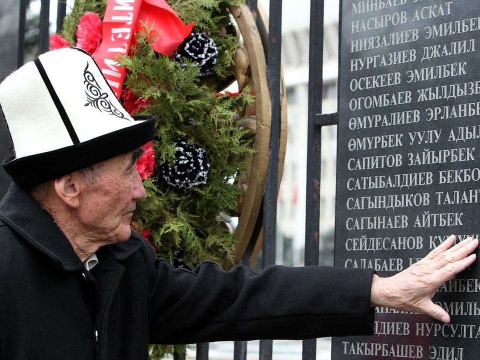 Ein Mann trauert an einer Gedenktafel um einen Angehörigen, der beim Aufstand 2010 ums Leben kam. Bild von 2015