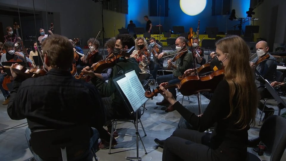 Viele Musikerinnen und Musiker spielen in einer Kirche Instrumente.