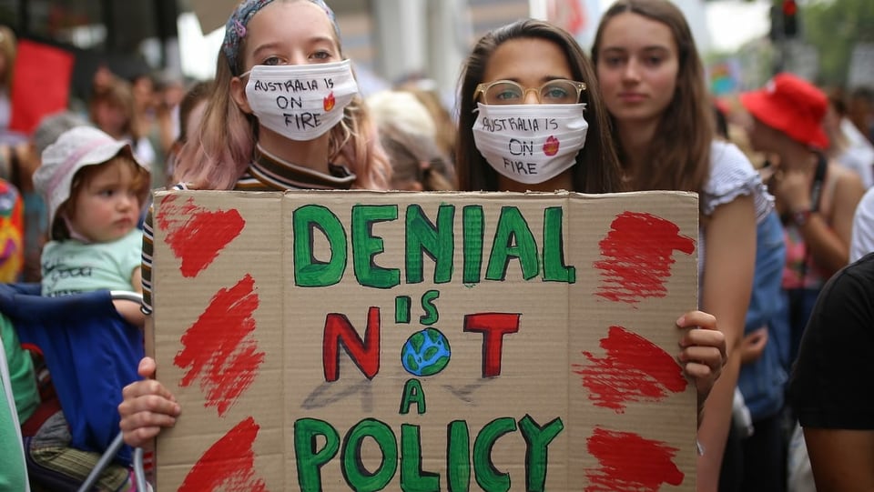 Klimademonstrantinnen mit einem Pappschild