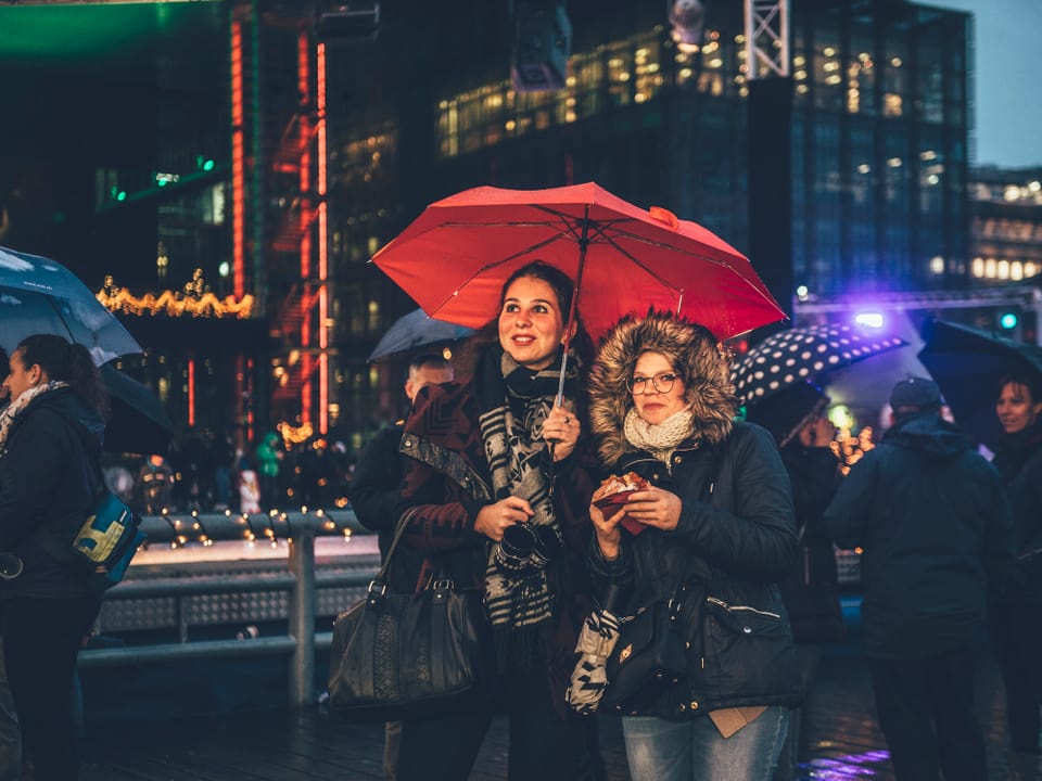 Besucherinnen mit rotem Regenschirm auf dem Europaplatz