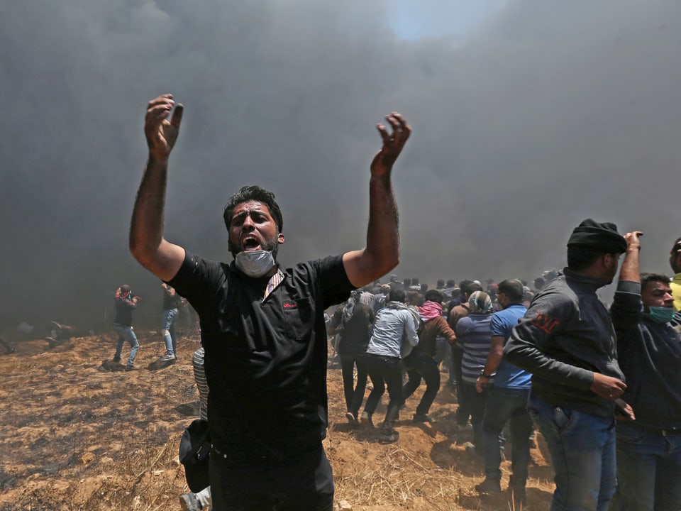 Ein Palästinenser reisst die Arme in den Himmel.