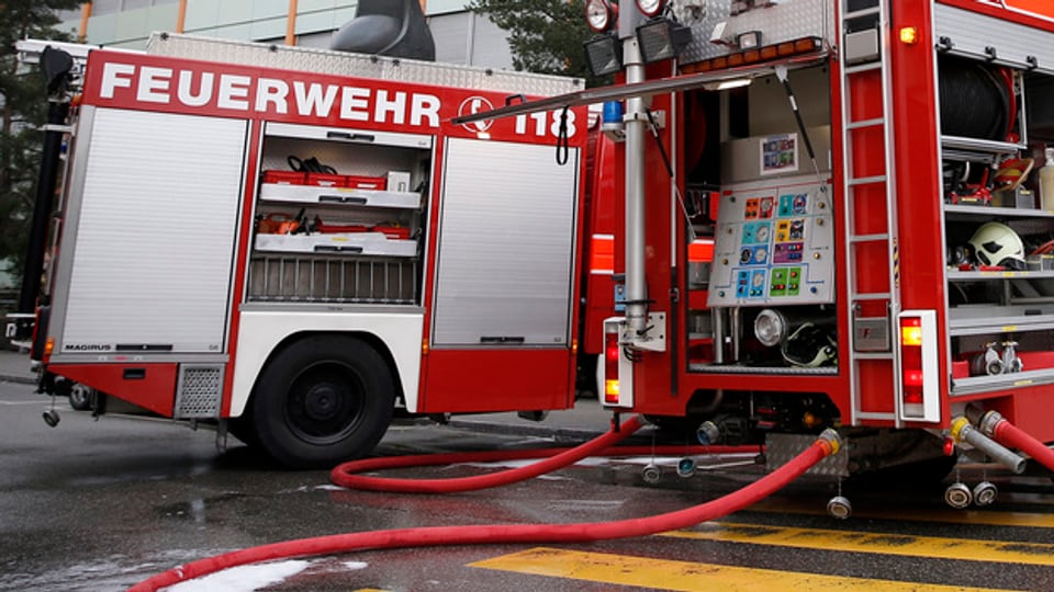Feuerwehrfahrzeuge mit Schlauch im Einsatz