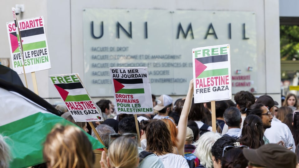 Protestierende mit Schildern für palästinensische Solidarität vor einem Universitätsgebäude.