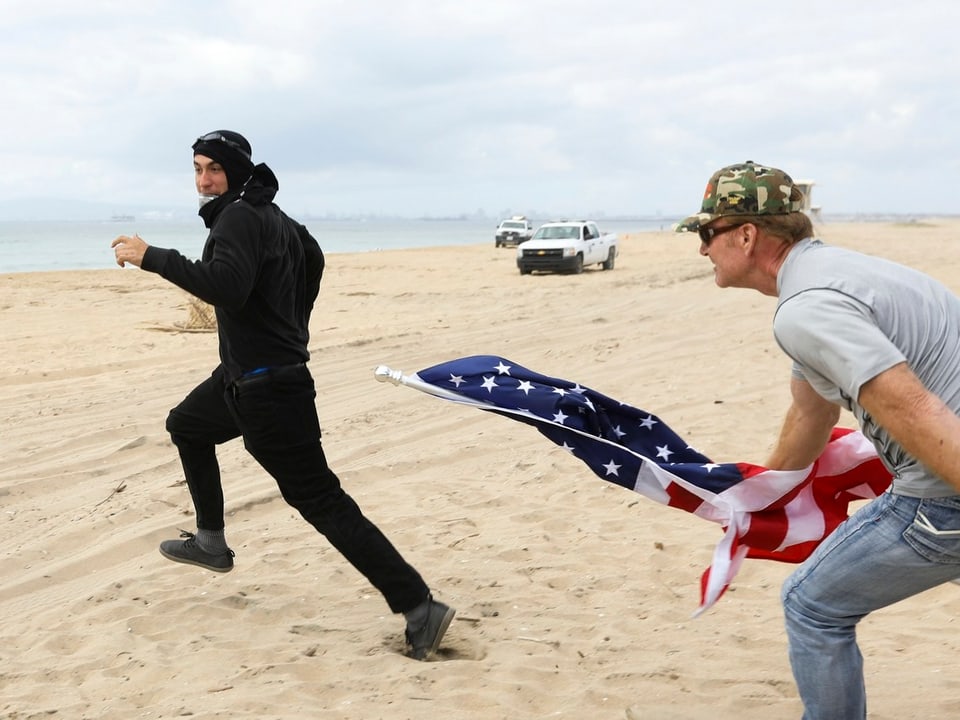 Ein Trump-Befürworter jagt mit einer Flagge einen Gegner in die Flucht.