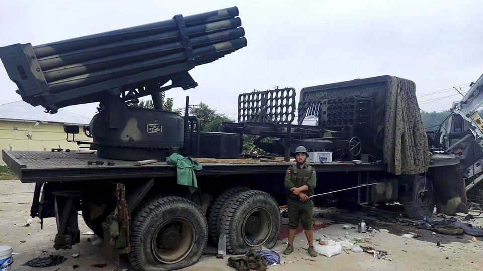 Ein Mitglied der Myanmar National Democratic Alliance Army posiert vor einem mit Raketen beladenen Militärlastwagen.