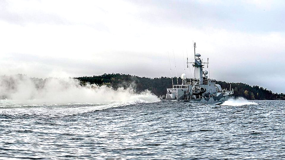Aufklärungsschiff der Schwedischen Marine zieht eine lange Rauchfahne hinter sich her.