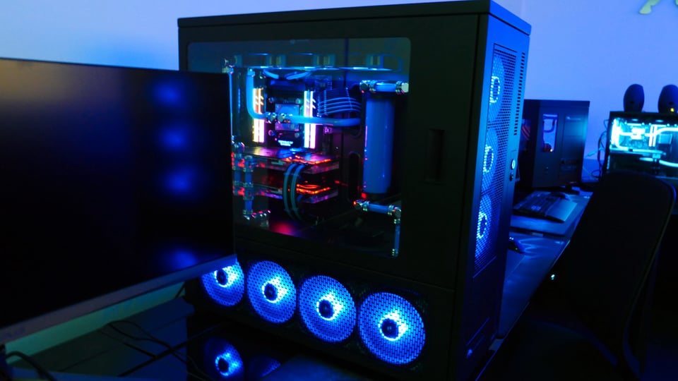 Ein abgedunkelter Raum, der in blauen Farben leuchtet und diverse PCs mit blauen LEDs die leuchten.
