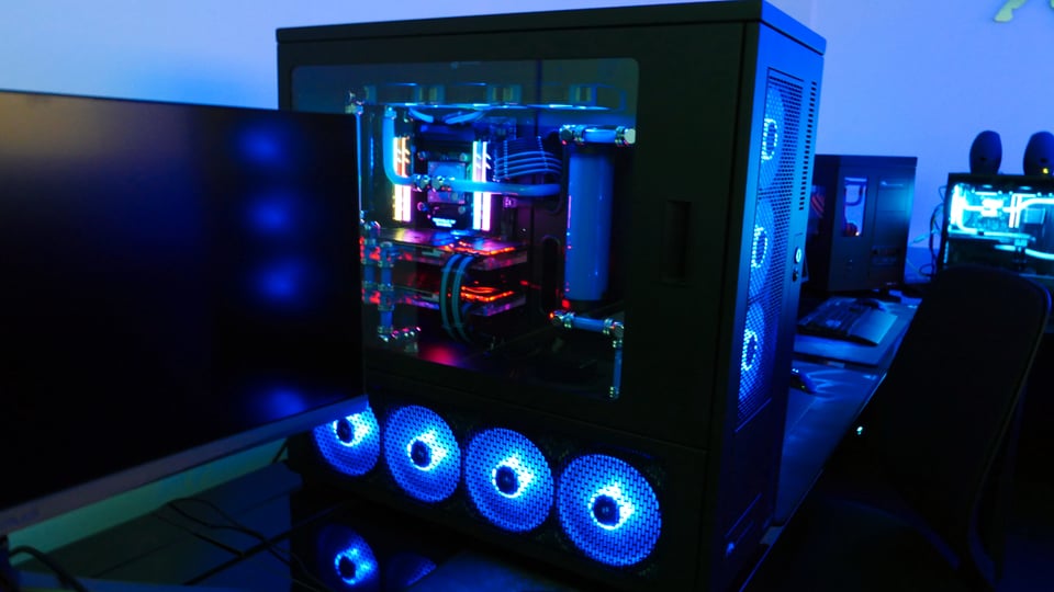 Im Showroom Ein abgedunkelter Raum, der in blauen Farben leuchtet und diverse PCs mit blauen LEDs die leuchten.