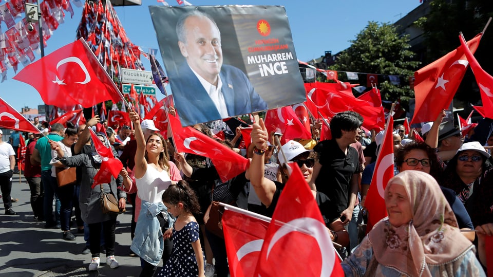 Menschenmenge schwenkt Türkei-Fahnen und Plakate mit Ince-Porträts.