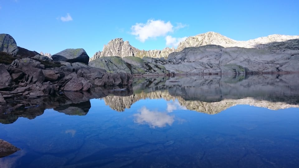 Hexensee Alp Caschlè, Krüzlipass/UR-GR: Bergwelt spiegelt sich auf dem See.
