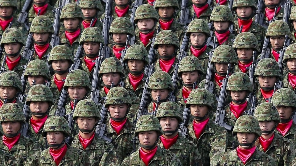 Angehörige der japanischen Streitkräfte stehen dicht nebeneinander.